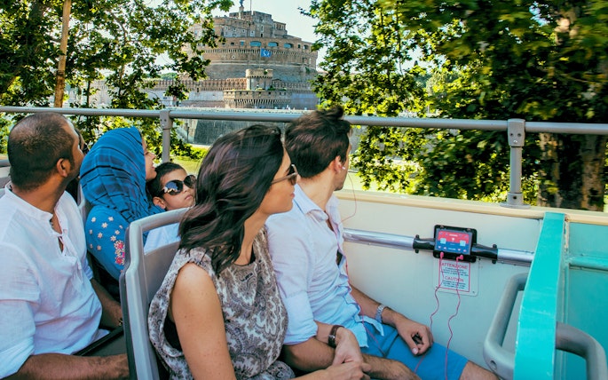 Travellers on a bus listening to an audio guide near Castel Sant'Angelo, Rome.