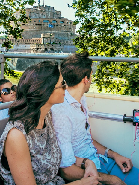 Travellers on a bus listening to an audio guide near Castel Sant'Angelo, Rome.