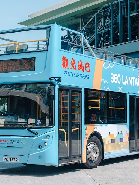 Open-top bus for Lantau Island Hop-on Hop-off Tour near cable cars.