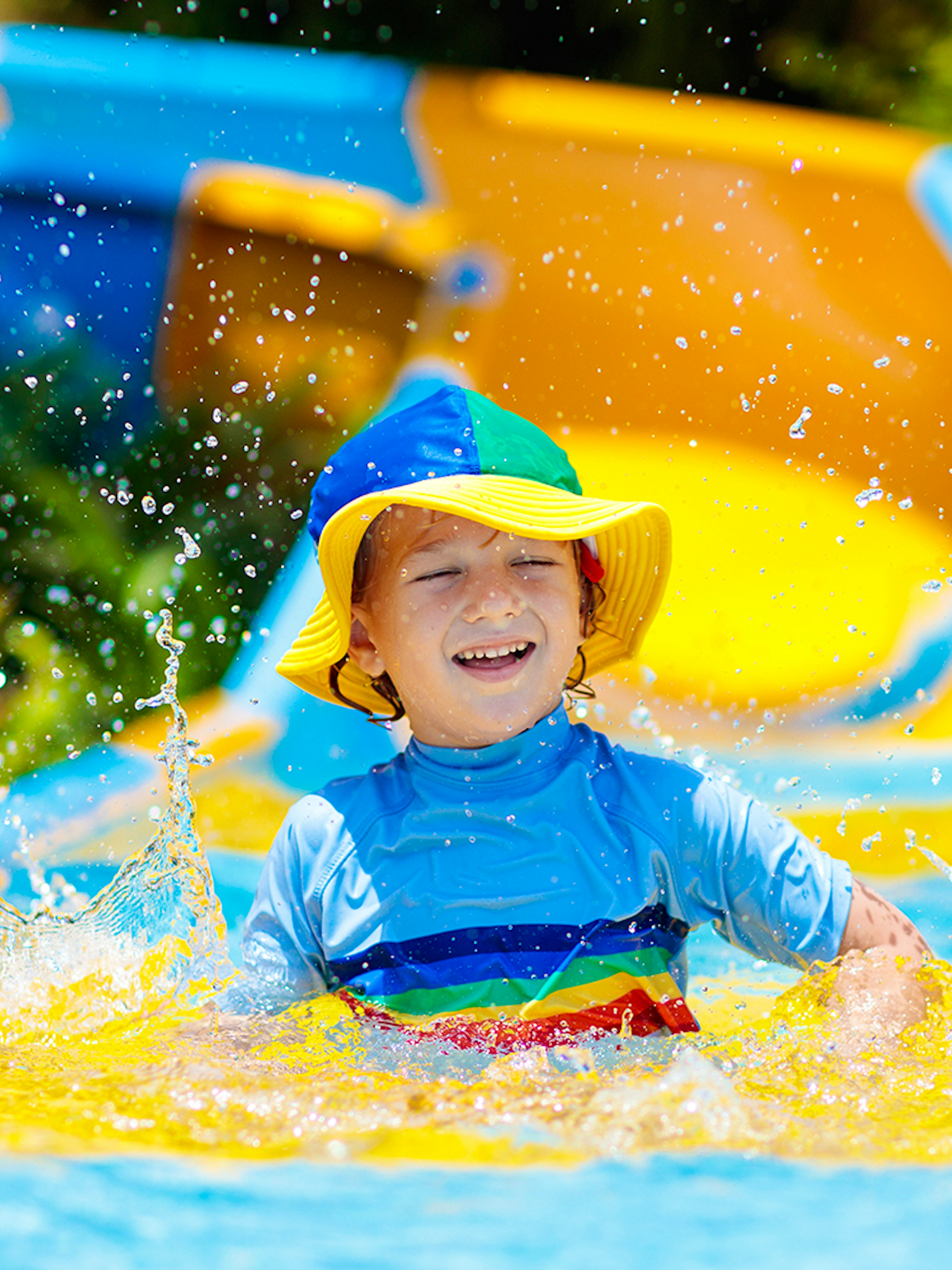 Child enjoying a colorful water slide at a water park.