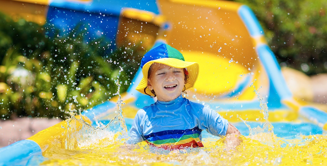 Child enjoying a colorful water slide at a water park.
