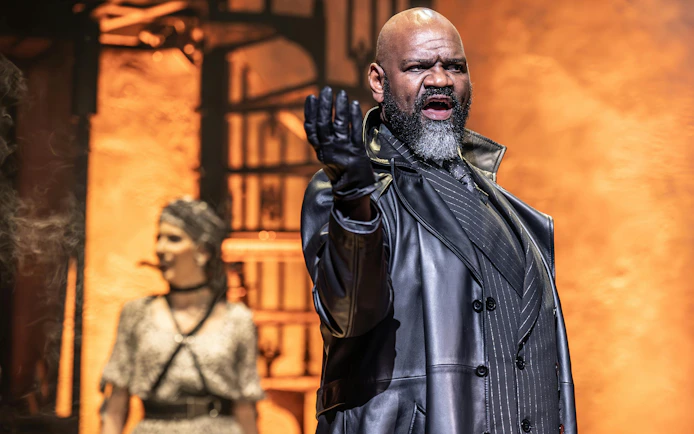 Stage performance of Hadestown in West End with actor in dramatic pose.