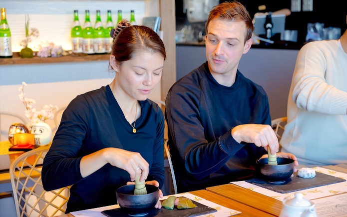 Husband and wife making matcha with Japanese sweets in Tokyo.