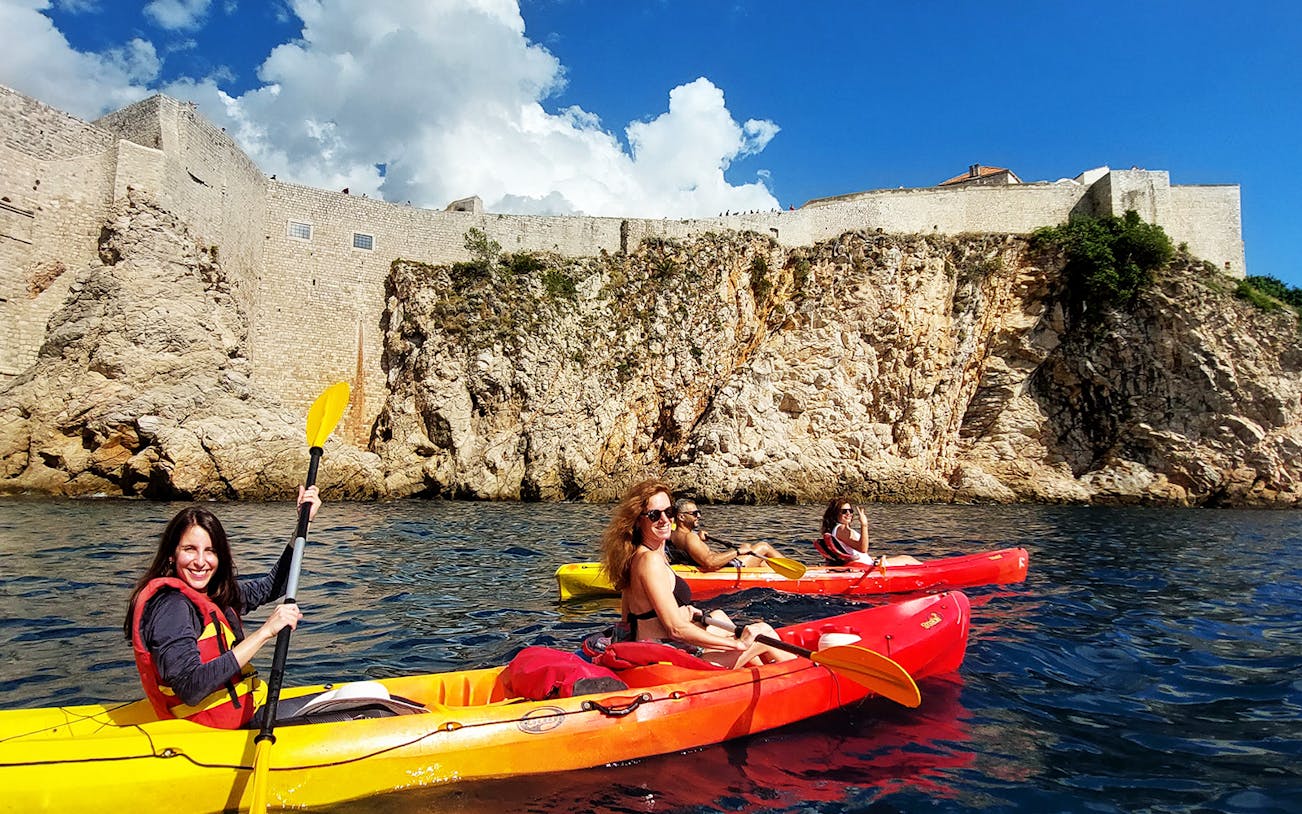 Kayakers paddling near Dubrovnik's historic city walls.