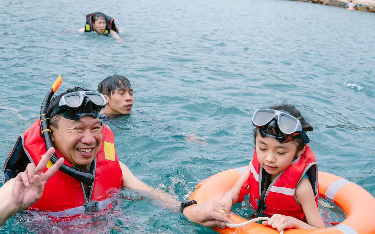 Group snorkeling in Nha Trang's Green Oasis Beach with life vests and goggles.