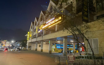 Sapa night street view with illuminated shooting range sign and parked bus.