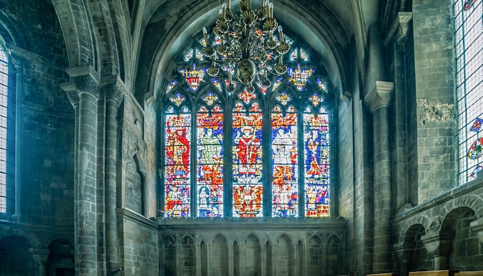Stained glass windows inside Canterbury Cathedral, showcasing intricate medieval designs.
