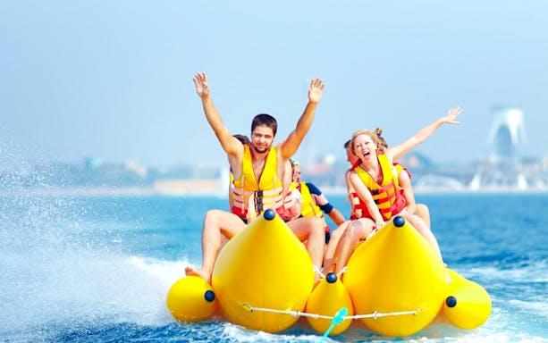 Family enjoying double banana boat ride in Dubai waters.