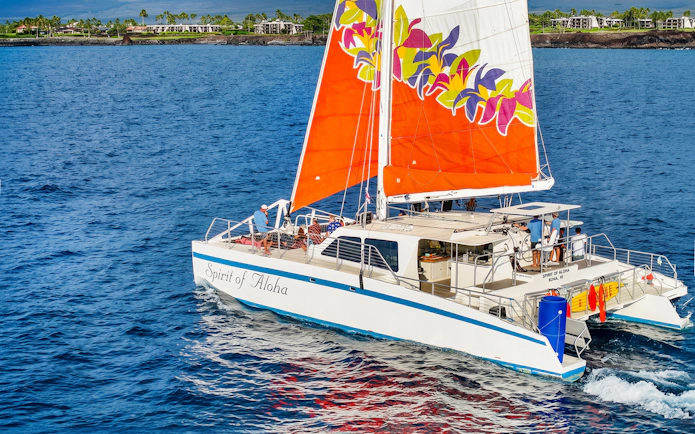 Catamaran sailing near Waikoloa on Big Island with vibrant sails.