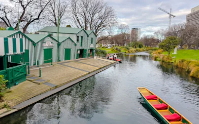 Antigua Boat Sheds by the Avon River in Christchurch, with a punt boat in the water.