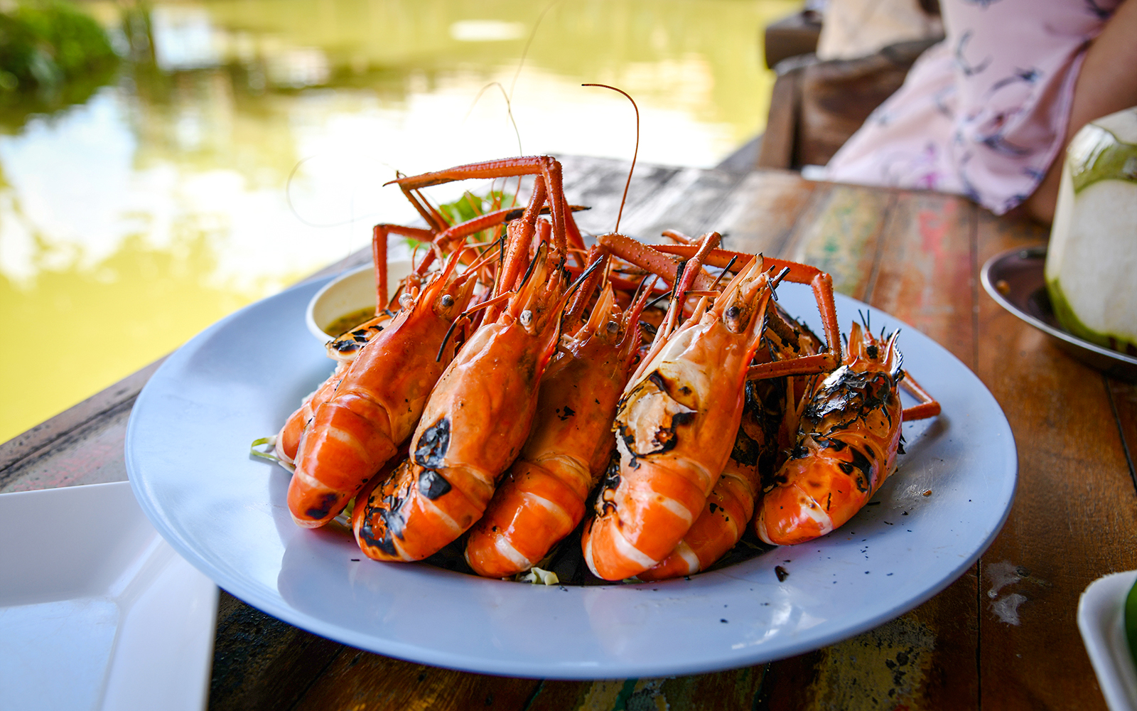 Grilled prawns on a plate at a riverside restaurant.