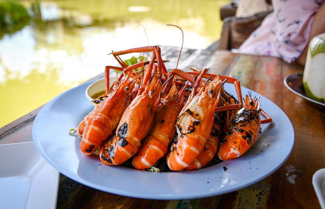 Grilled prawns on a plate at a riverside restaurant.