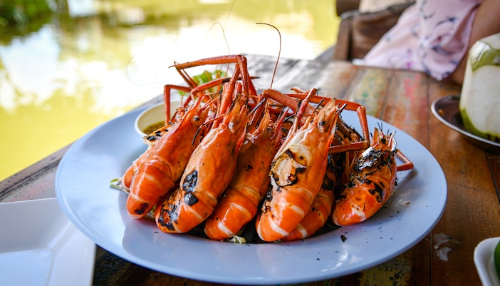 Grilled prawns on a plate at a riverside restaurant.