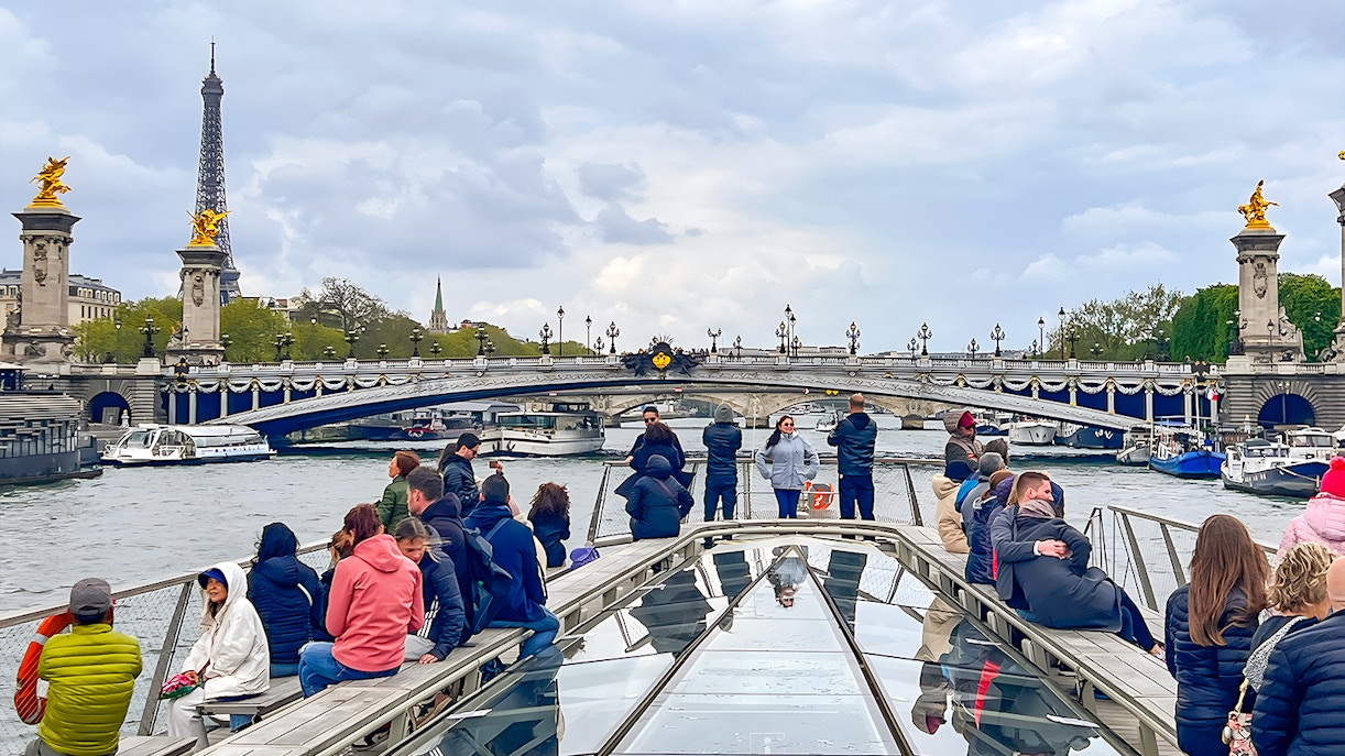 Tourists enjoying a Seine River Sightseeing Cruise with a stunning view of the Eiffel Tower in Paris