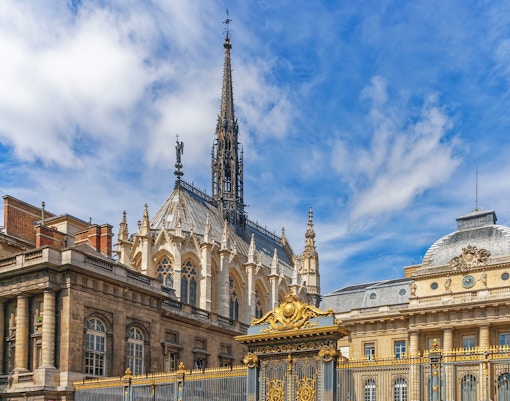 Sainte Chapelle's Gothic spire and ornate facade in Paris, France.