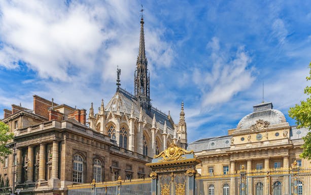 Sainte Chapelle's Gothic spire and ornate facade in Paris, France.