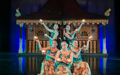 Performers at Devdan Show in Bali, presenting traditional Indonesian dance with lit props.