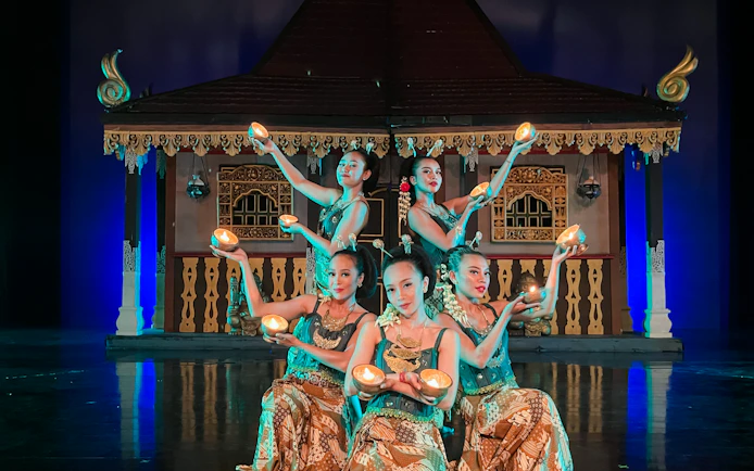 Performers at Devdan Show in Bali, presenting traditional Indonesian dance with lit props.