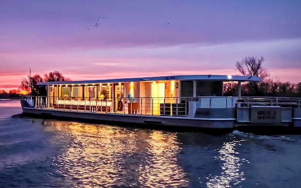 Berlin evening cruise boat on river at sunset.