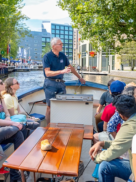 Small group enjoying a canal cruise in Amsterdam on an open boat.