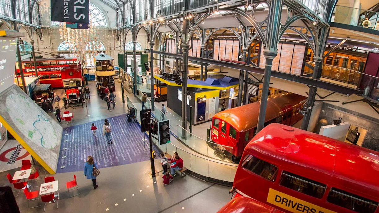 Interior view of London Transport Museum with vintage buses and visitors exploring exhibits.