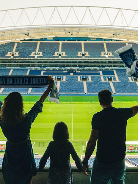 Visitors holding scarves in FC Porto stadium overlooking the field.