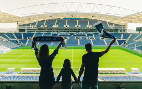 Visitors holding scarves in FC Porto stadium overlooking the field.