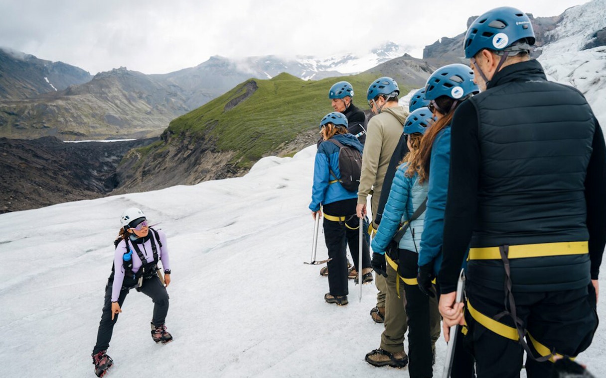 Tour guide explaining ice maze and glacier crevasse to group on glacier.