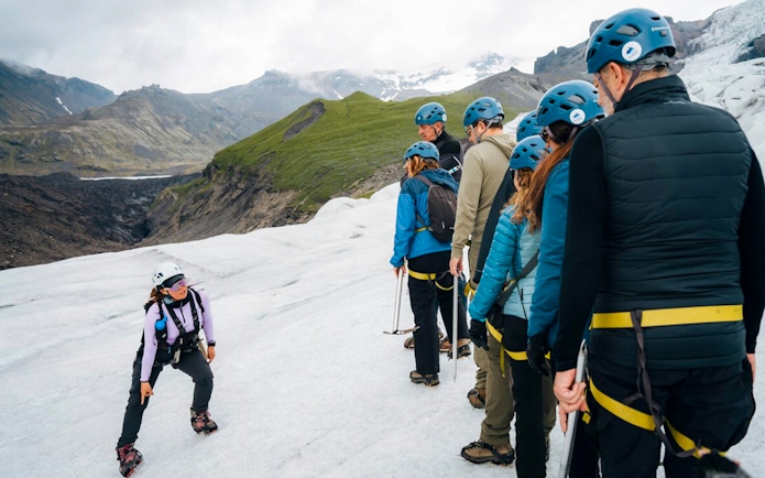 Tour guide explaining ice maze and glacier crevasse to group on glacier.