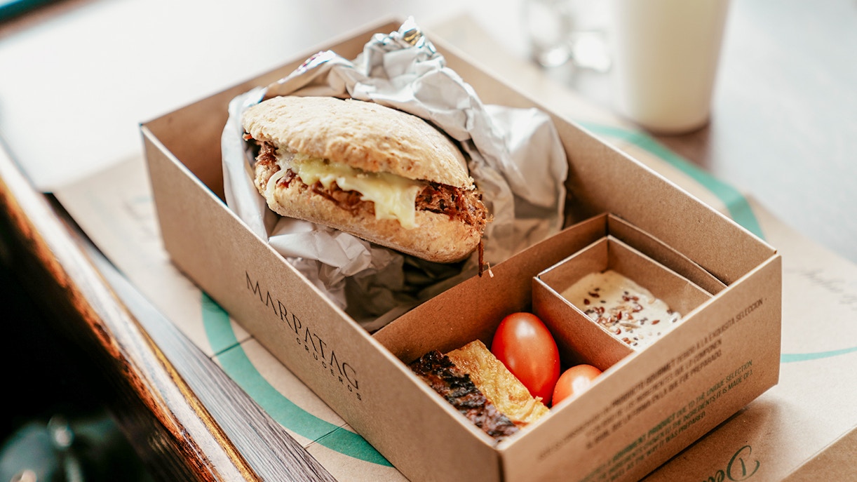 Boxed meal with sandwich, cherry tomatoes, and dessert on Perito Moreno, Spegazzini & Upsala cruise tour.