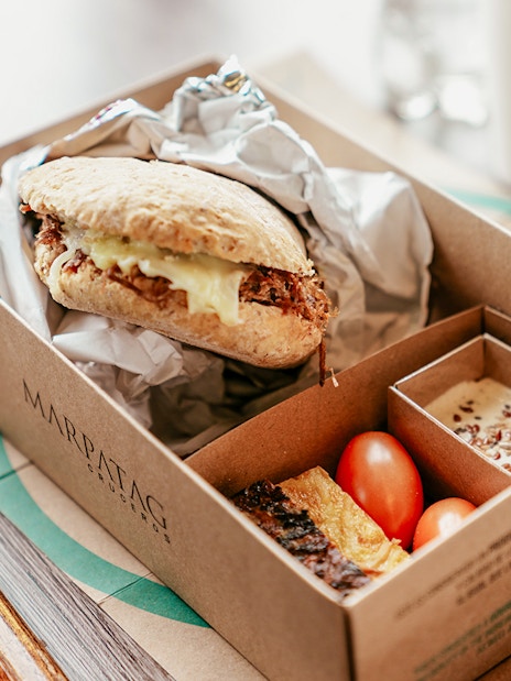 Boxed meal with sandwich, cherry tomatoes, and dessert on Perito Moreno, Spegazzini & Upsala cruise tour.