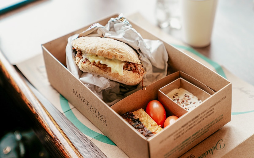 Boxed meal with sandwich, cherry tomatoes, and dessert on Perito Moreno, Spegazzini & Upsala cruise tour.