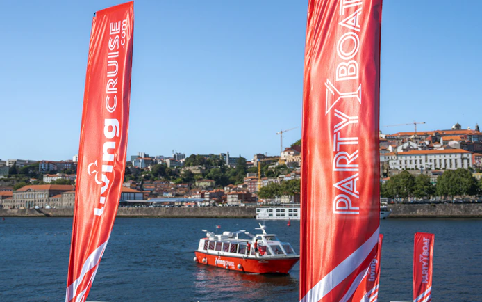 Party boat on Douro River with Porto cityscape in the background.