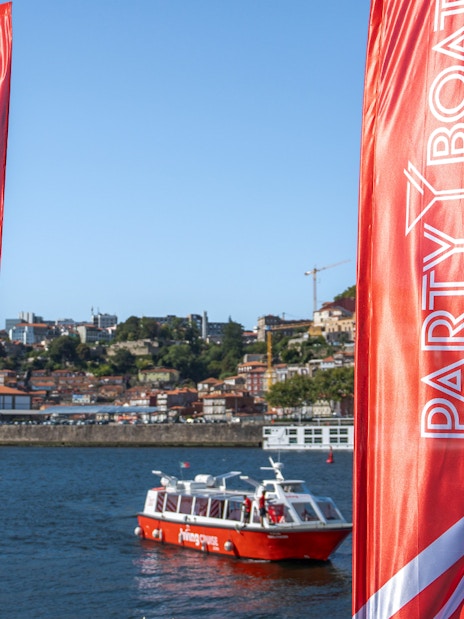 Party boat on Douro River with Porto cityscape in the background.