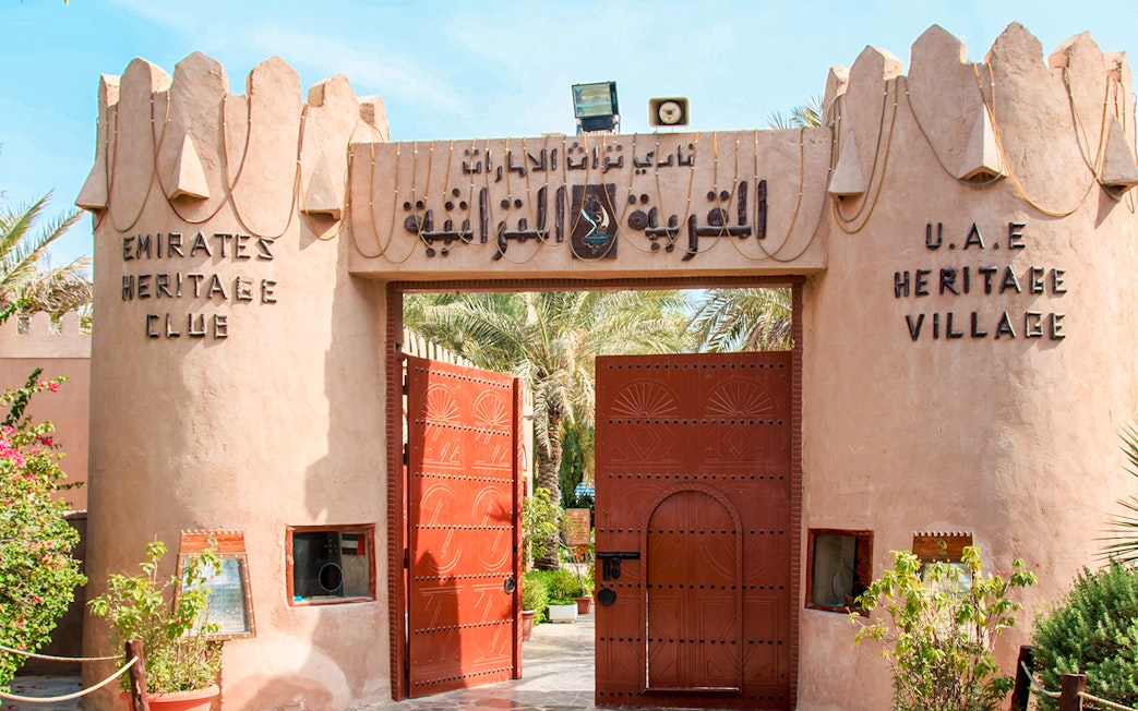 Heritage Village entrance with open wooden gates in Abu Dhabi.