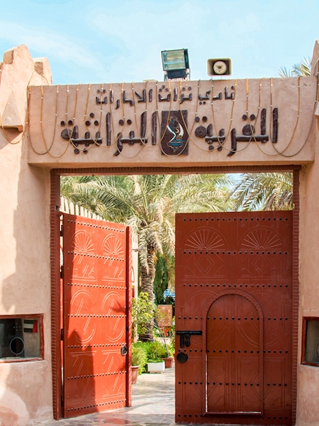 Heritage Village entrance with open wooden gates in Abu Dhabi.