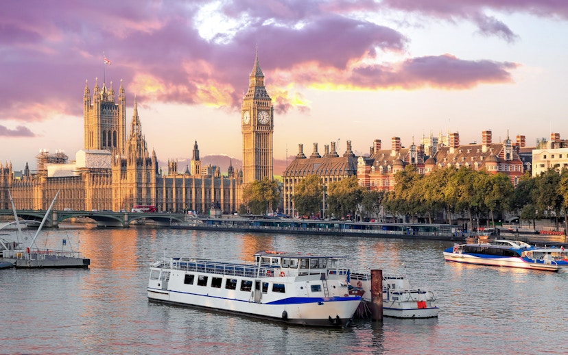 Cruise boat on Thames River with view of Big Ben and Houses of Parliament, London.
