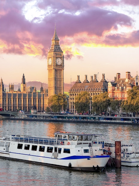 Cruise boat on Thames River with view of Big Ben and Houses of Parliament, London.