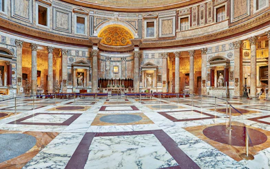 Interior view of the Pantheon in Rome, showcasing its ornate marble floor and ancient columns.