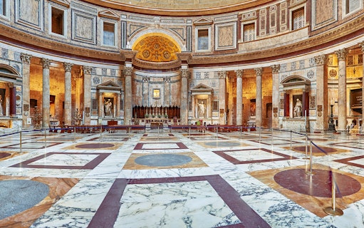 Interior view of the Pantheon in Rome, showcasing its ornate marble floor and ancient columns.