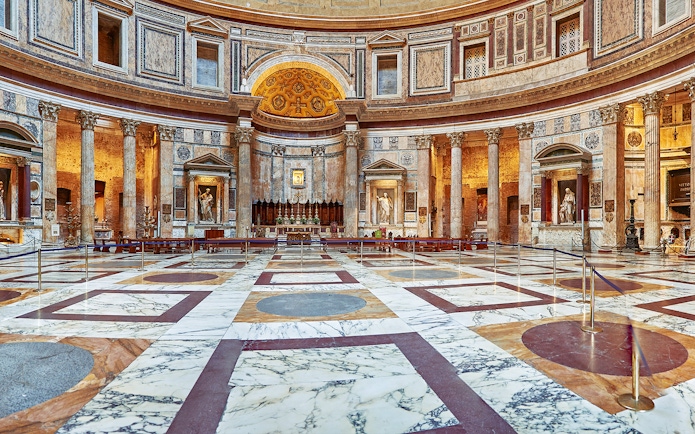 Interior view of the Pantheon in Rome, showcasing its ornate marble floor and ancient columns.