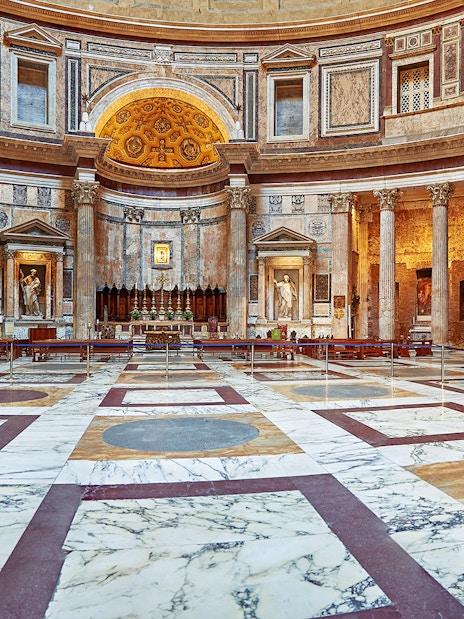 Interior view of the Pantheon in Rome, showcasing its ornate marble floor and ancient columns.