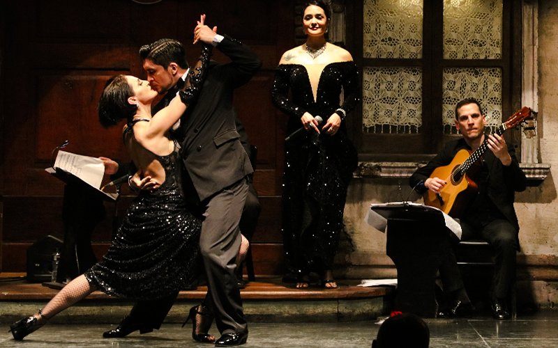 Tango dancers performing at Aljibe Tango Show in Buenos Aires with live musicians.