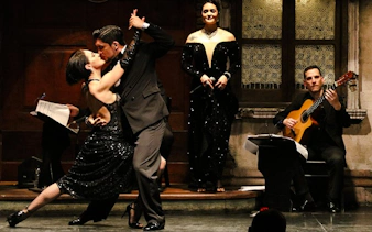 Tango dancers performing at Aljibe Tango Show in Buenos Aires with live musicians.