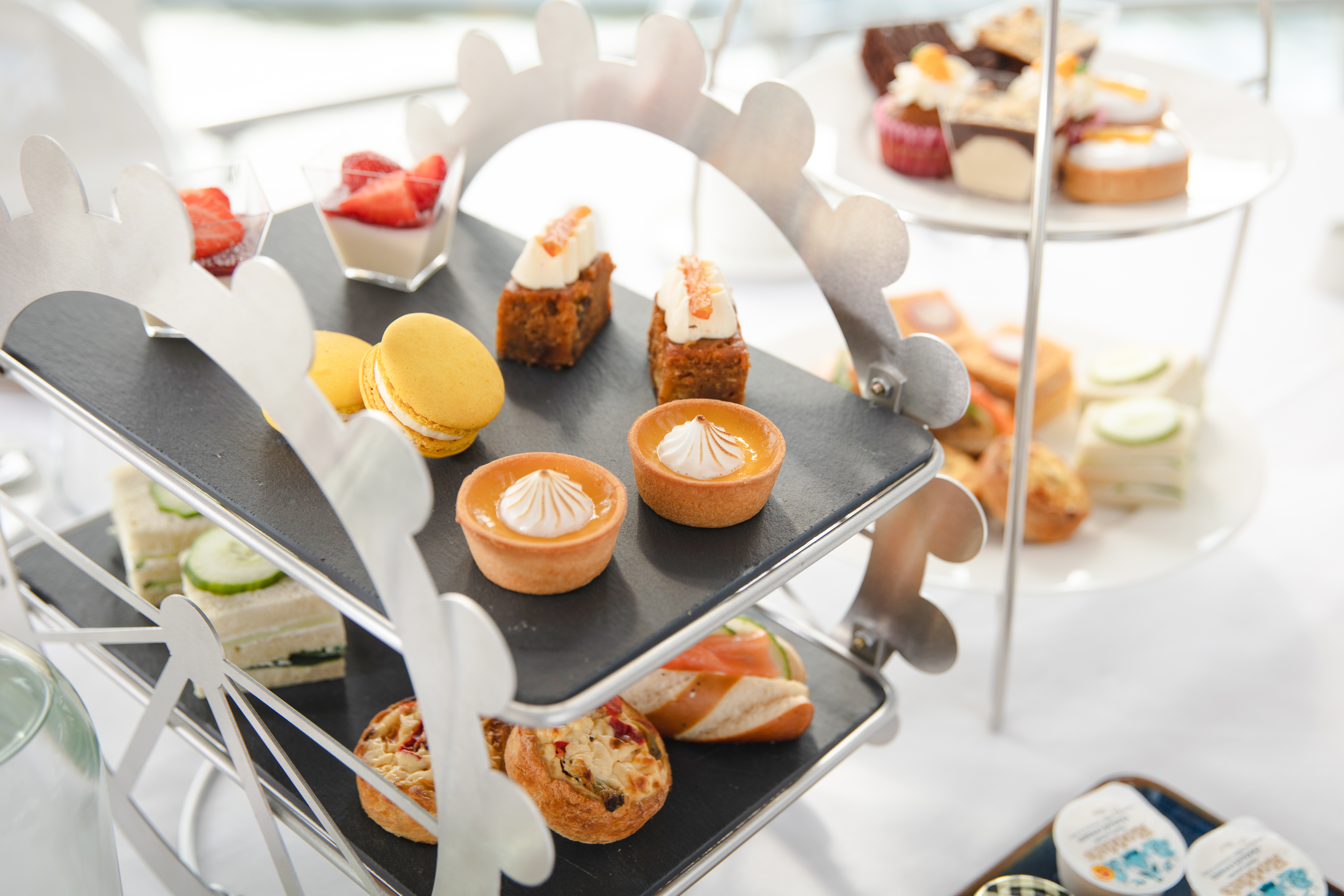 Afternoon tea pastries and sandwiches on a Ferris wheel stand for London Eye experience.