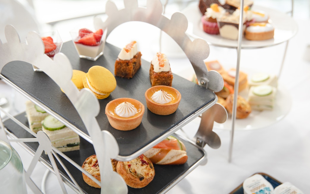 Afternoon tea pastries and sandwiches on a Ferris wheel stand for London Eye experience.