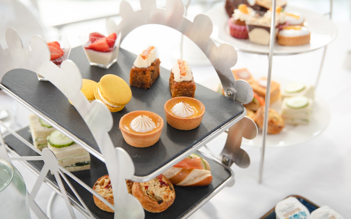 Afternoon tea pastries and sandwiches on a Ferris wheel stand for London Eye experience.