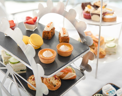 Afternoon tea pastries and sandwiches on a Ferris wheel stand for London Eye experience.