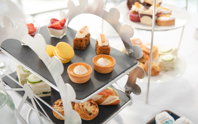 Afternoon tea pastries and sandwiches on a Ferris wheel stand for London Eye experience.