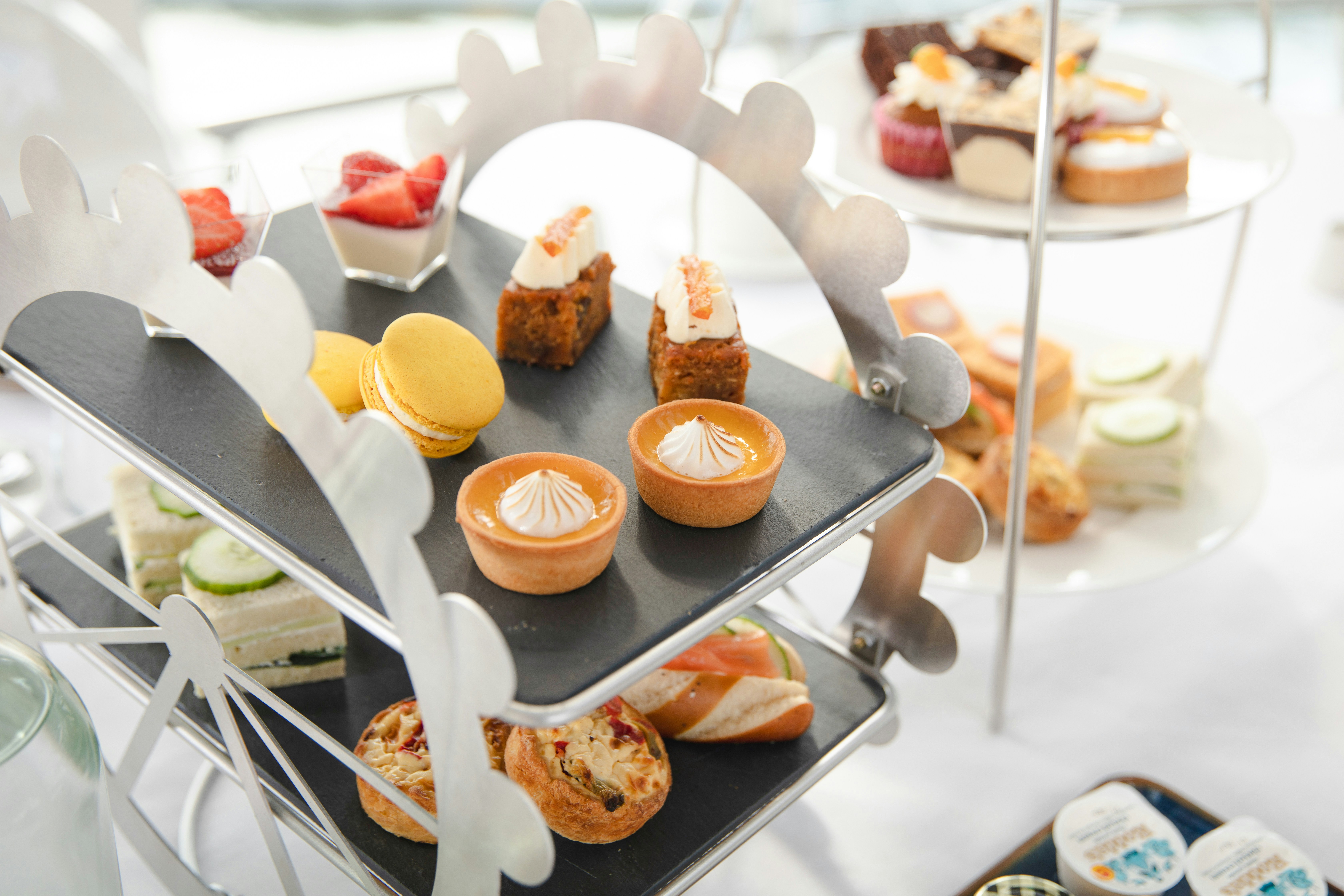 Afternoon tea pastries and sandwiches on a Ferris wheel stand for London Eye experience.